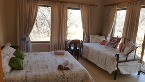 A room with two beds, a desk, and a chair.