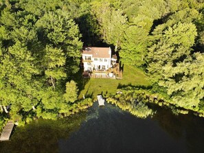 Enjoy a serene retreat surrounded by dense woods and a tranquil waterfront setting.