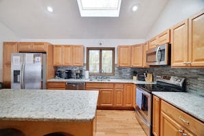 Enjoy cooking in this well-equipped kitchen with a gas stove, refrigerator, microwave, and dishwasher.