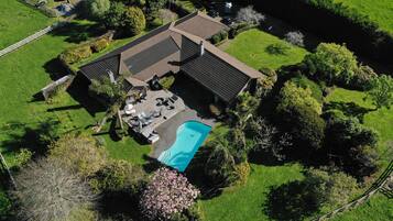 Enjoy a serene retreat with a spacious backyard, swimming pool, and lush greenery.