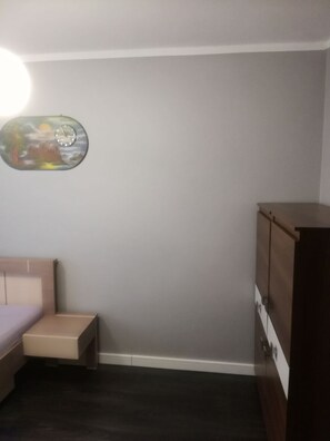 Cozy bedroom with a single bed, nightstand, and dresser.