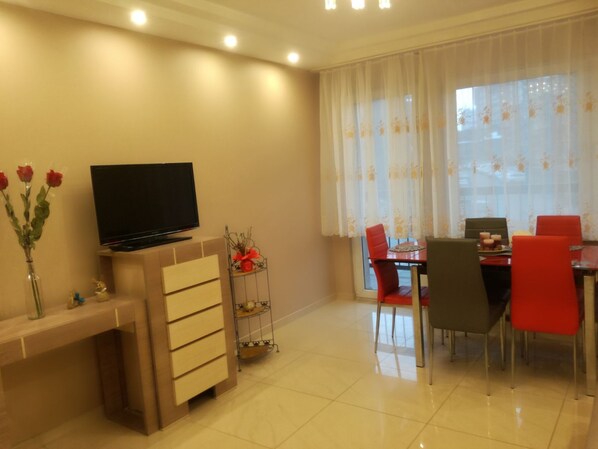 Relax in this stylish living room with a flat-screen TV, dining area for four, and a beautiful view.