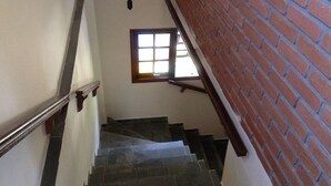 Eine Treppe mit Geländer, Fenster und einer Ziegelwand.