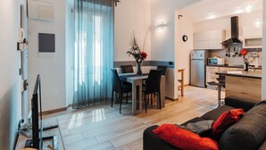 A modern apartment with a dining area, kitchen, and living room. - I FRAGOLI A SANTA CROCE (Firenze)