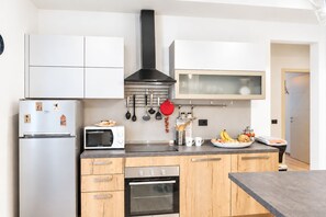 A modern kitchen with a refrigerator, microwave, oven, and a stove. - I FRAGOLI A SANTA CROCE (Firenze)