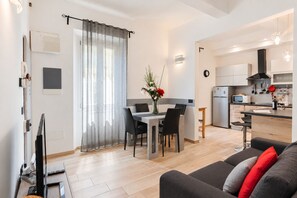 A modern apartment with a dining area, kitchen, and living room. - I FRAGOLI A SANTA CROCE (Firenze)