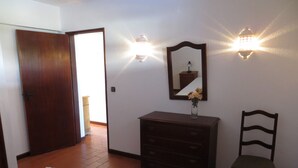 A bedroom with a bed, a dresser, a chair, and a mirror. - Magnificently located apartment with sea view (Lagos)