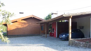 Une cabane en bois avec un garage fermé et une allée gravillonnée.