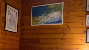 Une pièce aux murs lambrés, avec un lit, un tableau encadré et une peinture accrochée au mur.