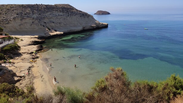A coastal area with clear waters, rocky cliffs, and a small island in the distance. - Apartment La Invencible Terreros in 1st line of beach (San Juan de los Terreros)