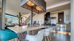 A modern kitchen with a wooden countertop, white chairs, and a staircase leading to another level. - LAST MINUTE -  Design villa, climatized pool, sea views 6 pers. (Tijoco Bajo)