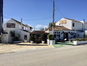Un bâtiment blanc avec une enseigne indiquant « Venta La Choza » et une autre enseigne pour le « Restaurant La Choza ».