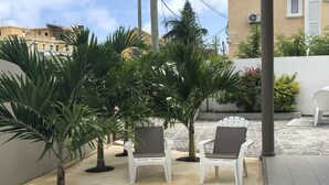 Eine Terrasse mit weißen Stühlen und einem kleinen Pool.
