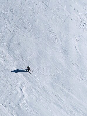 Une pente enneigée avec un skieur.