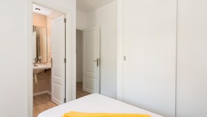 Ein Hotelzimmer mit Bett, Badezimmer mit Waschbecken und einem Kleiderschrank.
