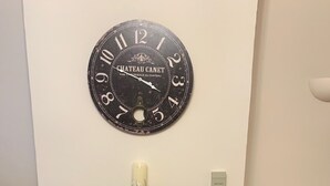 A living room with a brick fireplace, a large wall clock, and a candle on the mantel. - Fuzzy Duck Cottage. Over 100 5 star reviews on Trip Advisor. Sleeps 4  (Heacham)