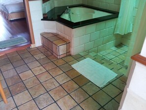 A bathroom with a sink, tiled floor, and a small bench. - Wonderland Private Chalet Port Dickson (Port Dickson)