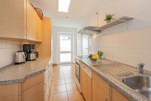 A kitchen with granite countertops, stainless steel appliances, and a built-in dishwasher. - Cozy vacation apartment in Ahlbeck with terrace, 500 m to the beach (Seebad Ahlbeck)