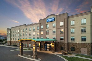 A multi-story hotel with a prominent City Express sign, a covered entrance, and a brick facade.