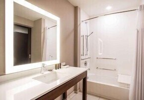 A bathroom with a double sink, a large mirror, a shower, and a bathtub.