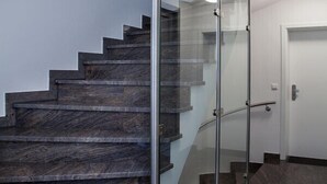 A modern staircase with glass railings and dark marble steps. - 5 star apartment on Lake Hopfensee directly on the lake with 2 terraces & underground parking space (Hopfen am See)