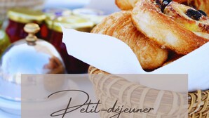 Un panier de viennoiseries et un pot de confiture.