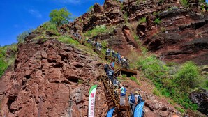Un paisaje montañoso y rocoso con una escalera que asciende.