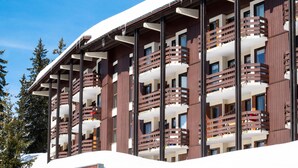 A multi-story hotel with balconies and a snow-covered roof.