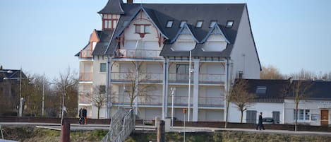 Un edificio de varios pisos con un estilo arquitectónico tradicional, que presenta un techo a dos aguas pronunciado y una chimenea destacada.