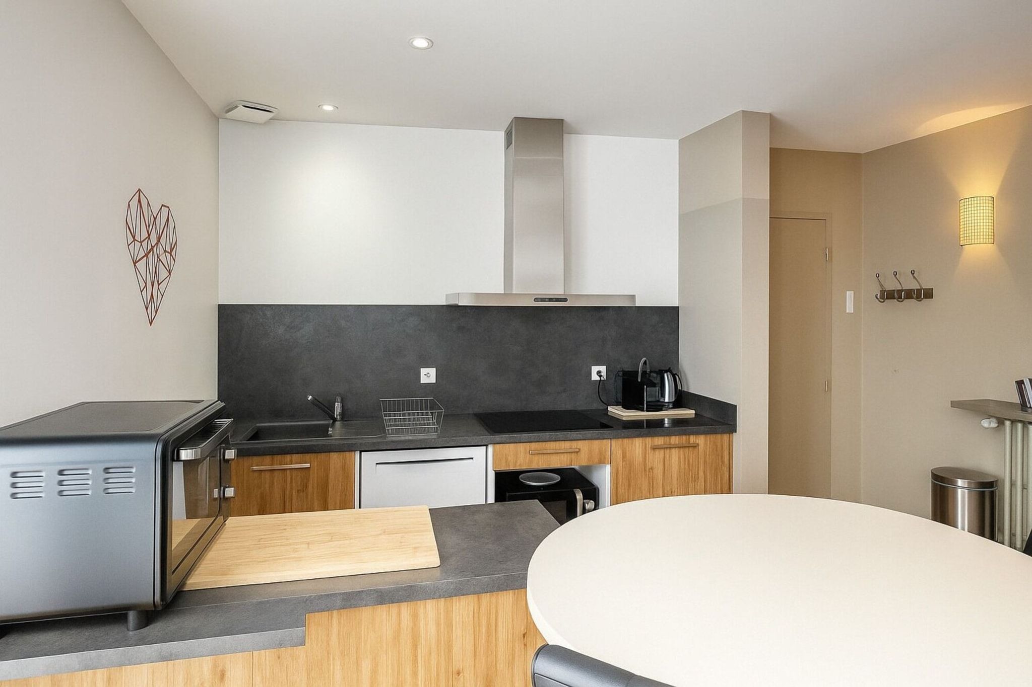 A modern kitchen with a built-in stove, a microwave, a sink, and a dining area with a table.