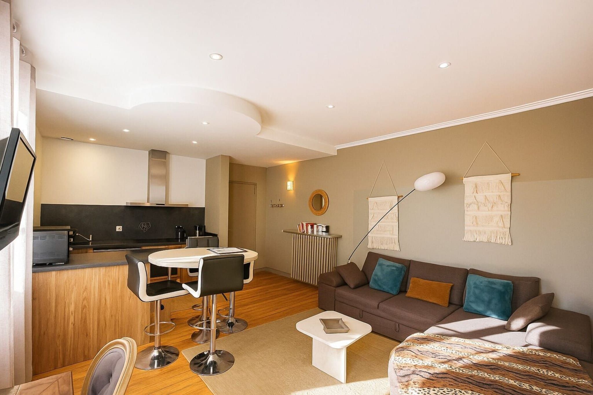 A modern living room with a sofa, coffee table, and a dining area with chairs.