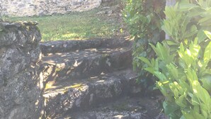 A stone staircase leading up to a grassy area with a stone wall in the background. - Gabarier's house in the historic heart of the medieval village of La Roque Gageac (La Roque-Gageac)