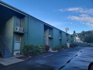 A row of green buildings with satellite dishes, air conditioning units, and a clear sky. - Location, location, location!  Ocean view!  Swimming & surfing within steps! (Kihei)