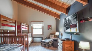 A cozy bedroom with bunk beds, a desk, a chair, and a window with a view of trees. - Whistlepunk #12:  4 Bedroom, 3 Bath:  Slope Side, Wood Fireplace. (Snowshoe)