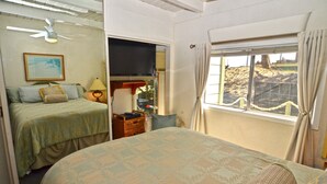 A room with two beds, a television, a window with a view, and a ceiling fan. - Magnificent Ocean views! On Oceano sandy beach with fire pit  (Oceano,)