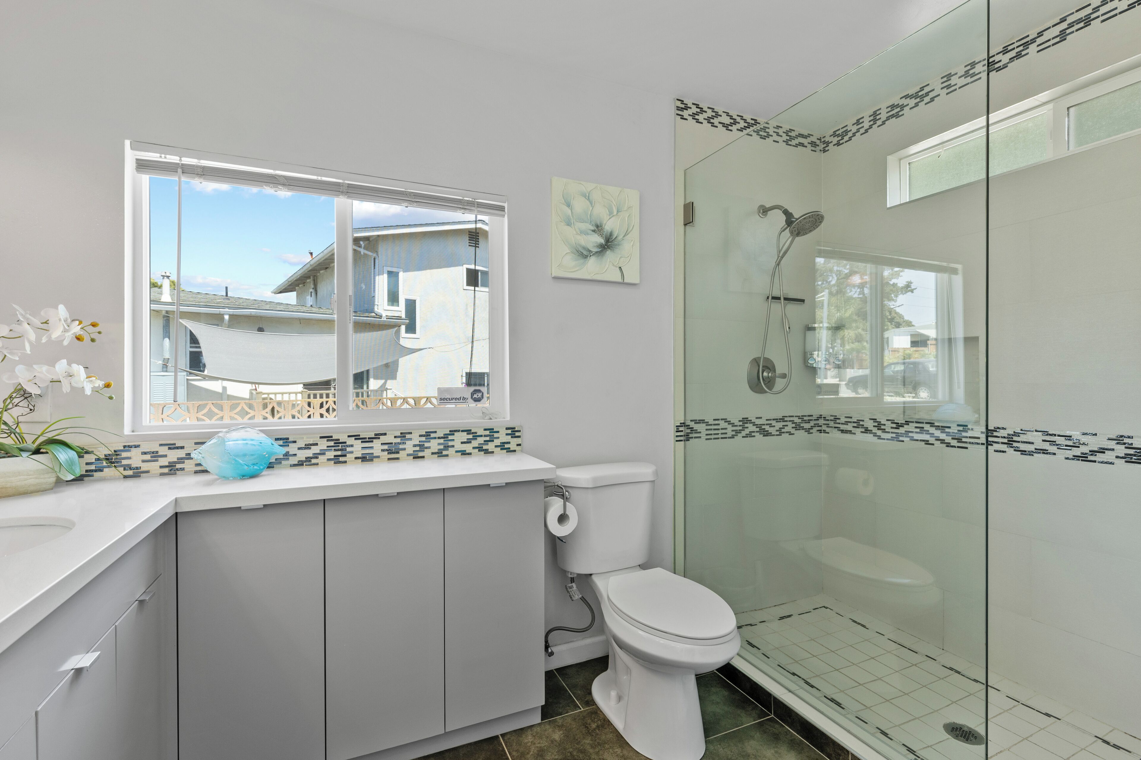 A modern bathroom with a toilet, sink, and glass-enclosed shower.
