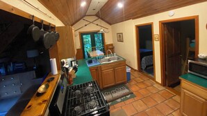 Una cocina con armarios de madera, una estufa y un ventilador de techo.