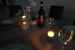 Savor a formal dining experience with a beautifully set table, complete with wine glasses and a bottle of wine.