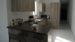 Cocina moderna con isla central, electrodomésticos integrados y armarios de madera.