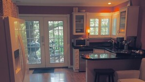 A kitchen with a refrigerator, microwave, and island.