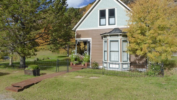 A two-story house with a bay window and a small turret-like structure. - Enjoy some R & R at this historic cottage in the best neighborhood in town! (Silverton)
