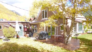 A house with a patio, outdoor seating, and a barbecue grill. - Enjoy some R & R at this historic cottage in the best neighborhood in town! (Silverton)