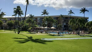 A hotel with a pool area, palm trees, and a well-maintained lawn. - Maui Sunset B407: Ocean view 1 Bed, 2 Bath, Kihei Condo, Sleeps up to four (Kihei)