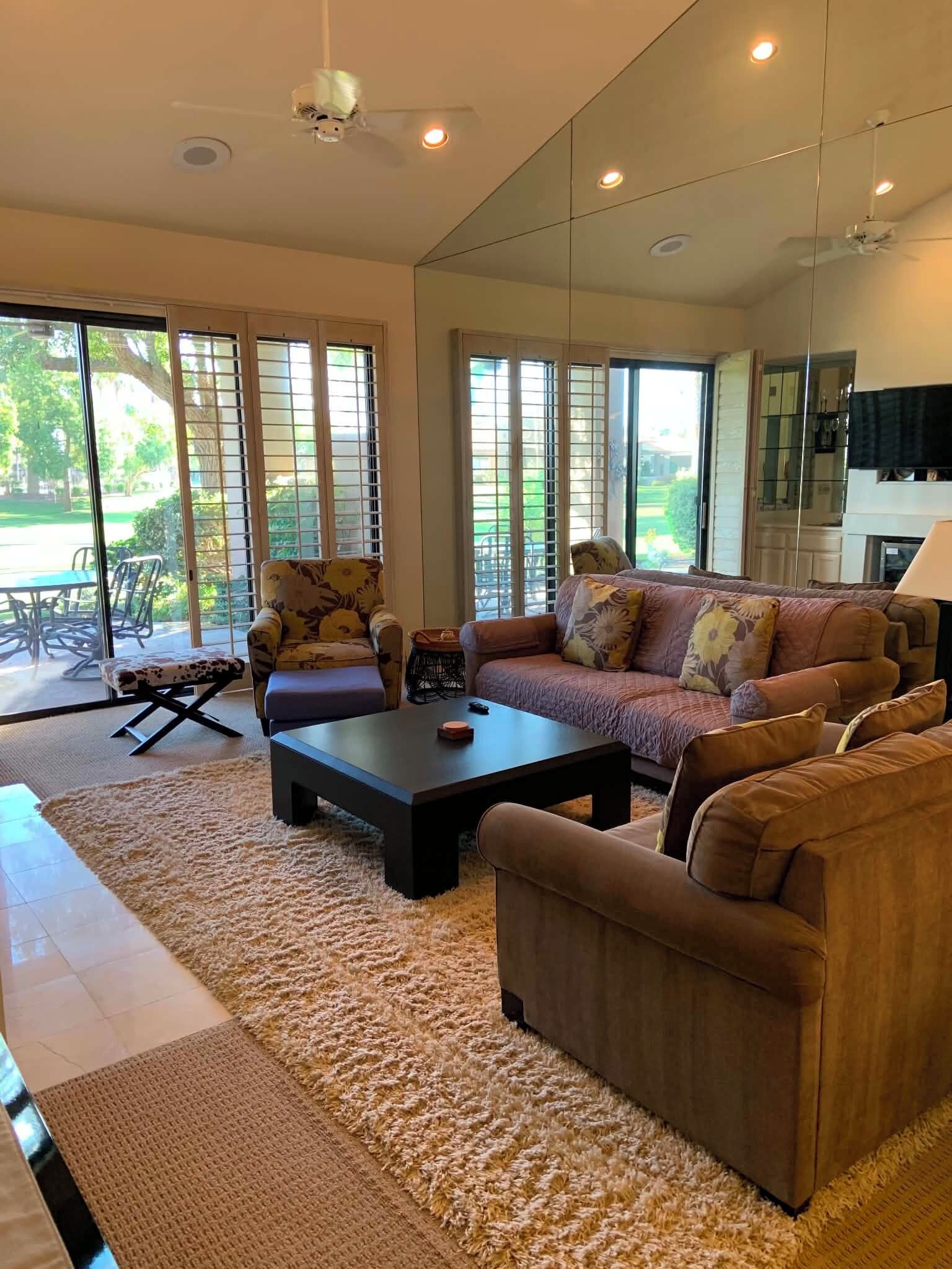 A spacious living room with a large sofa, a coffee table, and a dining area with a table and chairs.