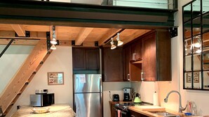 A modern kitchen with wooden cabinets, a stainless steel refrigerator, a built-in oven, and a wooden island with a microwave. - Bright, Modern Loft. 5 Miles to Ski Resort, National Park, or Downtown Jackson (Wilson)