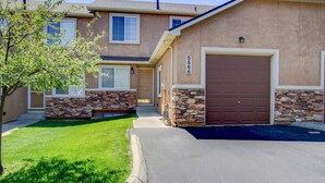A two-story house with a stone facade, a brown garage door, and a well-maintained lawn. - Pet Friendly-10 min to Peterson AFB-Pool Table (Colorado Springs)