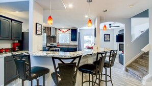 A modern kitchen with a central island, dark cabinetry, and pendant lighting. - Pet Friendly-10 min to Peterson AFB-Pool Table (Colorado Springs)