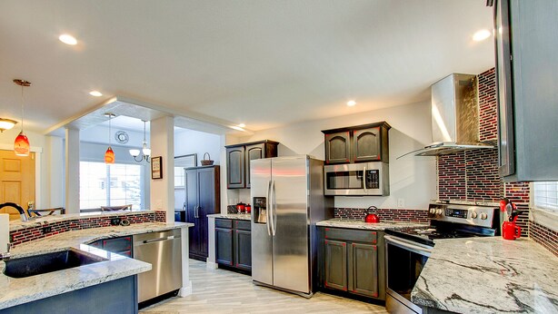 A modern kitchen with stainless steel appliances, a microwave, and a brick backsplash. - Pet Friendly-10 min to Peterson AFB-Pool Table (Colorado Springs)