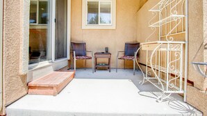 A small patio with two wicker chairs, a metal rack, and a wooden bench. - Pet Friendly-10 min to Peterson AFB-Pool Table (Colorado Springs)