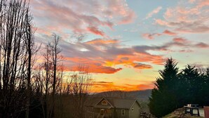 A house with a porch and a staircase leading to a deck. - Great location, beautiful mountain and sunset views, hot tub and shuffleboard. (Fairview)